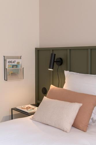 a bedroom with a bed and a table with a lamp at Hôtel Le Prieuré in Paray-le-Monial