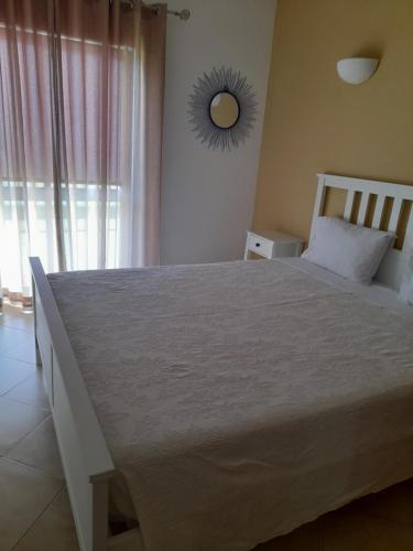 een slaapkamer met een groot wit bed met een raam bij Apartamento Maria in Lagos
