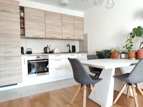 a kitchen with white cabinets and a white table and chairs at Lucy Apartment Split in Split