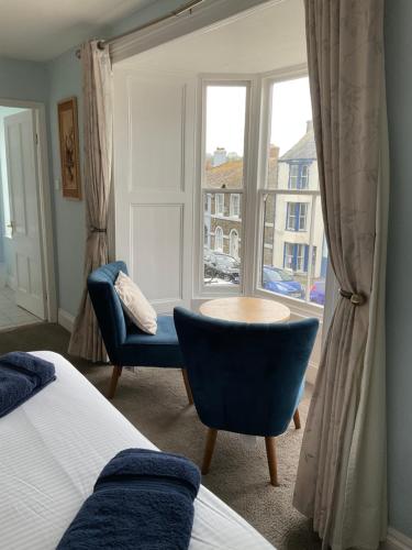 a bedroom with a bed and a chair and a window at No 52 bed and breakfast in Helston