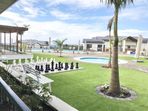 um grande quintal com um tabuleiro de xadrez e uma palmeira em Ballito Hills - Ocean View, Queen Bed & Free Wi-Fi em Durban