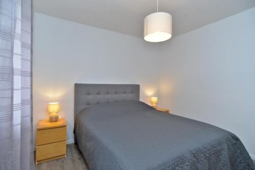 ein Schlafzimmer mit einem Bett und zwei Nachttischen mit Lampen in der Unterkunft Apartment Marija 2238 in Pula