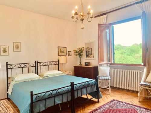 um quarto com uma cama e uma grande janela em Villa dei Pini em Montopoli in Val dʼArno