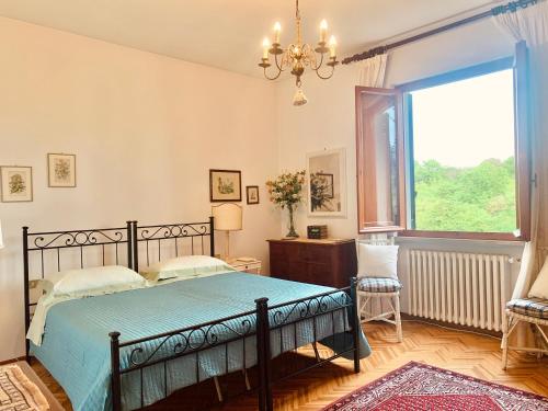 a bedroom with a bed and a large window at Villa dei Pini in Montopoli in Val dʼArno
