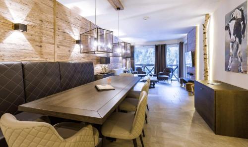 a dining room with a large wooden table and chairs at AvenidA Mountain Lodges Saalbach in Saalbach Hinterglemm