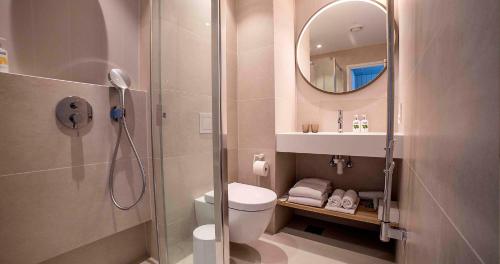 a bathroom with a shower and a toilet and a mirror at LaSpa Beach House in Laulasmaa