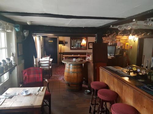 un bar con barra de madera, mesa y sillas en Glamping At The Fox Inn Bramdean en Bramdean