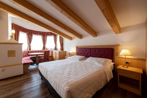 a bedroom with a large bed in a room at Hotel Cristina in Pinzolo