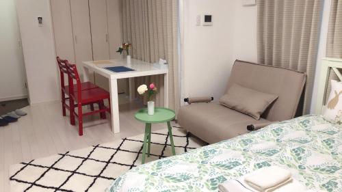 a bedroom with a bed and a table and a chair at Yuzuki Dome Osaka Kujo in Osaka