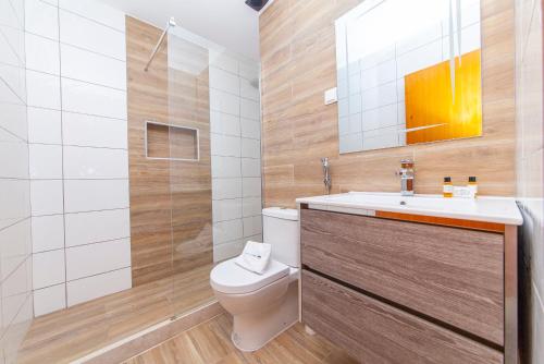 uma casa de banho com um WC, um lavatório e um espelho. em Rising Sun Apartments em Lagos