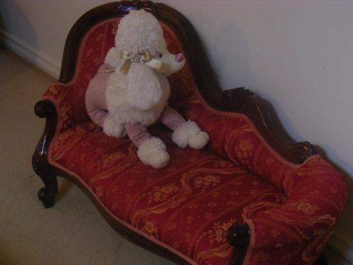 a teddy bear sitting on a red chair at Weeroona Bed And Breakfast in Rye