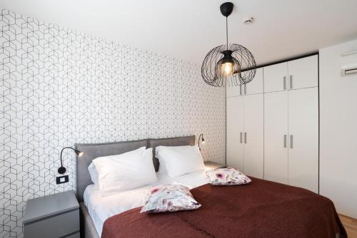 1 dormitorio con 1 cama con 2 almohadas en Marina Portoroz - Ammonite Apartment by Locap Group, en Portorož