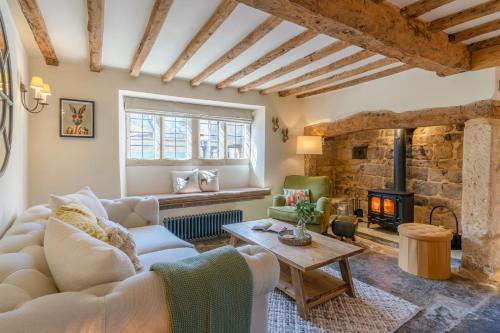 un soggiorno con divano e camino di Stone Cottage a Stanton