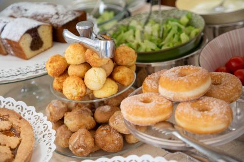a table topped with plates of donuts and other foods at Hotel Olimpia in Forte dei Marmi