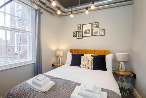 Un dormitorio con una cama con dos toallas encima. en Spurriergate Apartments- In the heart of the city centre, en York