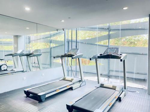 een fitnessruimte met 3 loopbanden in een kamer met ramen bij Sri Langit Hotel KLIA, KLIA 2 & F1 in Sepang