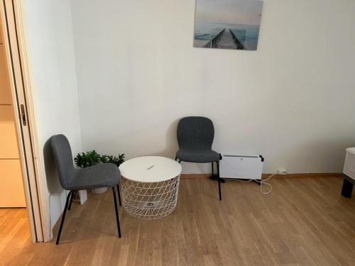 2 sillas y una mesa blanca en una habitación en Marken Studio Apartments, en Bergen