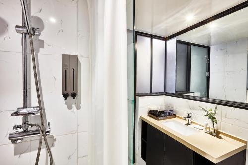 een badkamer met een wastafel en een douche bij The Interra Hotel Pyeongtaek in Pyeongtaek