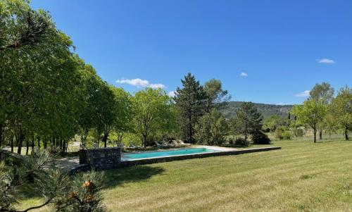 a swimming pool in the middle of a grass field at Domaine de Bonelli in Conqueyrac