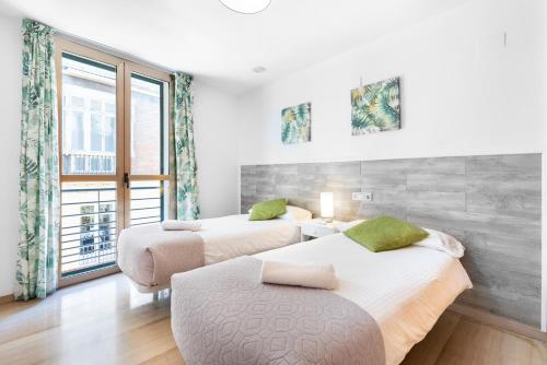 zwei Betten in einem Zimmer mit Fenster in der Unterkunft vistas panóramicas Calle Larios in Málaga