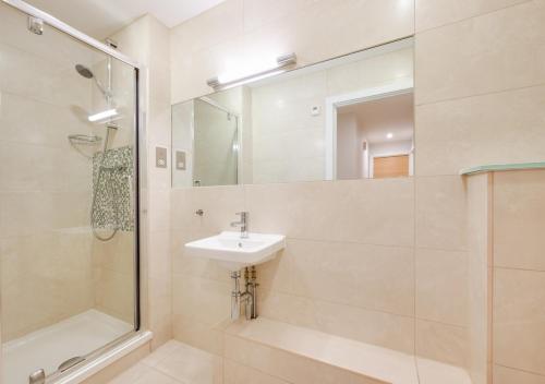 a bathroom with a sink and a shower and a mirror at 10 Ocean Point in Croyde