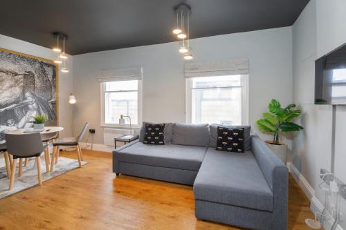 a living room with a gray couch and a table at Spurriergate Apartments- In the heart of the city centre in York
