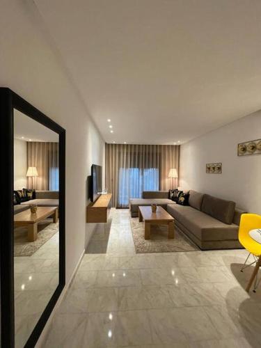 ein Wohnzimmer mit einem Sofa und einem TV in einem Zimmer in der Unterkunft Studio de luxe, en plein centre de Casablanca in Casablanca