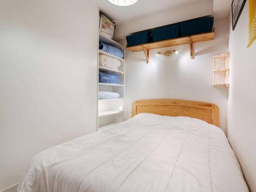 um pequeno quarto com uma cama e um closet em Studio Carnac, 1 pièce, 4 personnes - FR-1-477-108 em Carnac