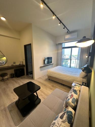 a living room with a bed and a couch at 北緯23點5度民宿-車位可預訂 in Hualien City
