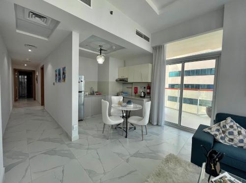 a living room and kitchen with a table and chairs at Dubai Canal Burj khalifa view 2bedroom apartment in Al Ḩamīdīyah