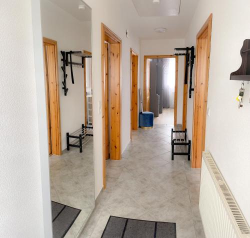 a hallway with wooden doors and a floor with rugs at Ferienwohnung Nordseemond in Norden
