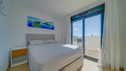 a bedroom with a bed and a large window at Duplex Finestrat in Finestrat
