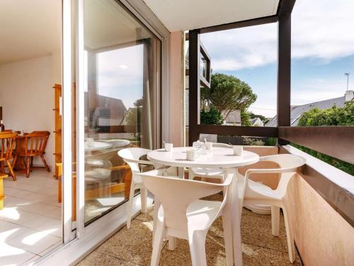 d'une table et de chaises blanches sur un balcon avec fenêtre. dans l'établissement Carnac - Studio cabine proche plage avec parking et animaux acceptés - FR-1-477-139, à Carnac