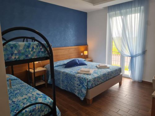 sypialnia z 2 łóżkami piętrowymi i oknem w obiekcie Stella Marina Paestum w Capaccio-Paestum