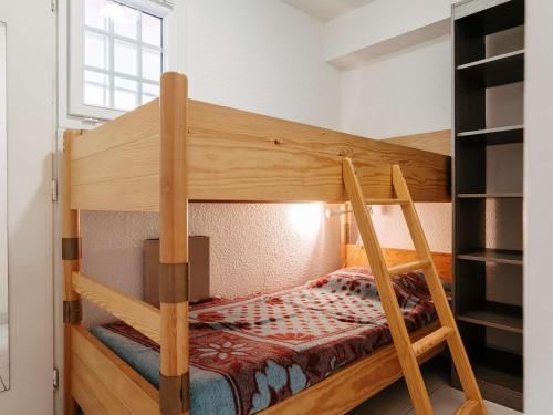 un lit superposé en bois dans une petite pièce dans l'établissement Carnac - Studio cabine proche plage avec parking et animaux acceptés - FR-1-477-139, à Carnac