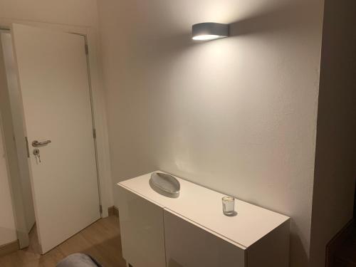 een kamer met een tafel met een licht aan de muur bij Fazenda Apartments - Apartment 2 in Lajes das Flores