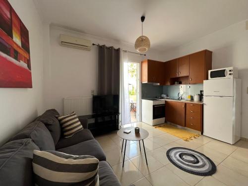 sala de estar con sofá y cocina en Seaside cozy apartment, en Ayiá