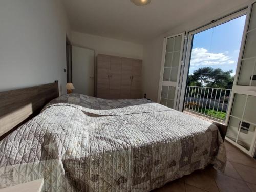 um quarto com uma cama e uma grande janela em Appartamento a 150 mt dal lungomare em Leuca