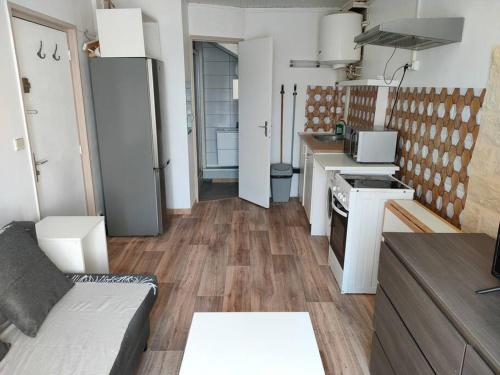 - une cuisine avec un canapé et une cuisinière dans l'établissement Studio meublé - Arpajon Eglise, à Arpajon