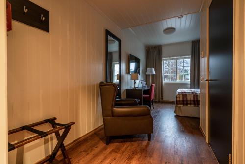 a living room with a chair and a bedroom at Vollan Gjestestue in Nordkjosbotn