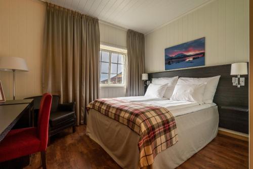 a hotel room with a large bed and a desk at Vollan Gjestestue in Nordkjosbotn