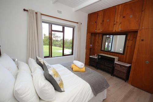 a bedroom with a large bed and a window at Deo-Lize in Bettyʼs Bay