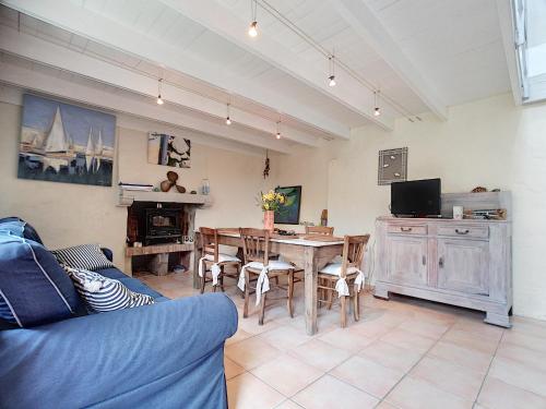 een woonkamer met een tafel en een blauwe bank bij Maison de vacances bord de mer in Plougrescant