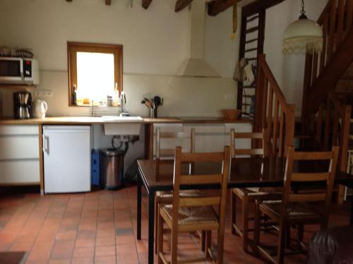 a kitchen with a table and chairs in a kitchen at Tranquillitude au Moulin Bouquet in La Chapelle-aux-Chasses
