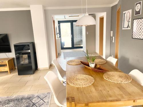 ein Esszimmer mit einem Holztisch und weißen Stühlen in der Unterkunft Ferienvilla am Brückelsee in Wackersdorf