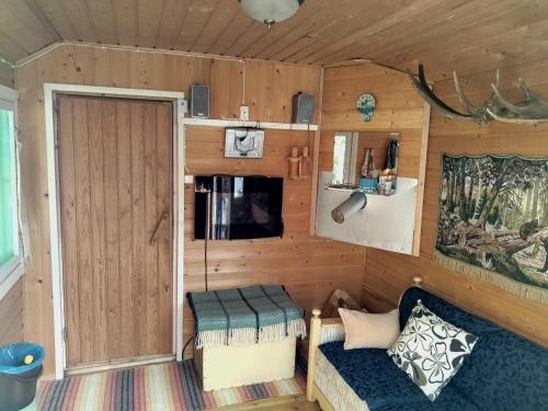 um quarto com uma porta e um sofá numa pequena casa em Mummola em Taluskylä