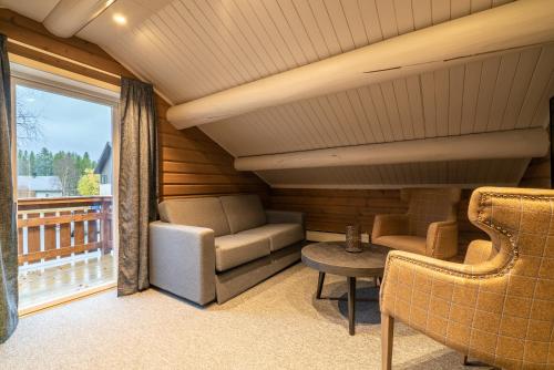 a room with a couch and a table and a window at Vollan Gjestestue in Nordkjosbotn