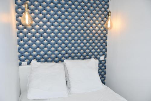un lit avec une tête de lit bleue et des oreillers blancs dans l'établissement Saint-Gilles-Croix-de-Vie, Charmant 2 pièces 'O GITE', à Saint-Gilles-Croix-de-Vie