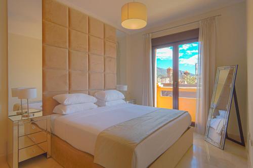 a bedroom with a large bed with a large window at Townhouse Azata Golf in Estepona