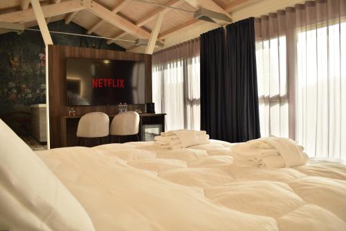 a large white bed in a room with a television at Royal Garden luxury rooms in Padova